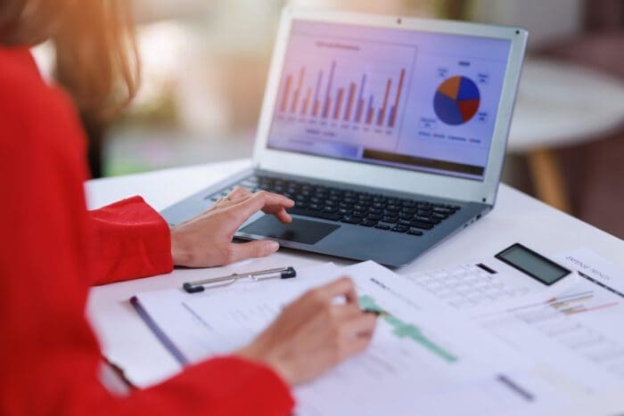 Woman analyzing data on laptop with graphs