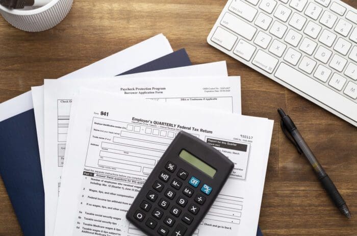 Tax forms and calculator on wooden desk