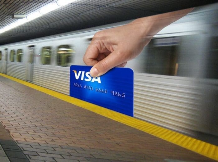 Hand holding Visa card at subway station platform - example of guerrilla marketing