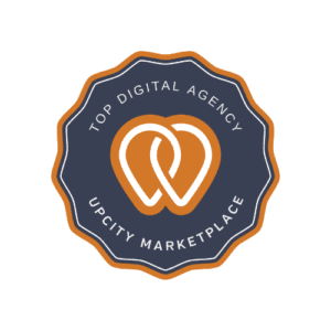 A circular badge with a dark blue background and an orange border. The center features an intertwined heart logo in orange and white, surrounded by the text "Top Digital Agency UpCity Marketplace." This design celebrates badges of excellence in the digital space.