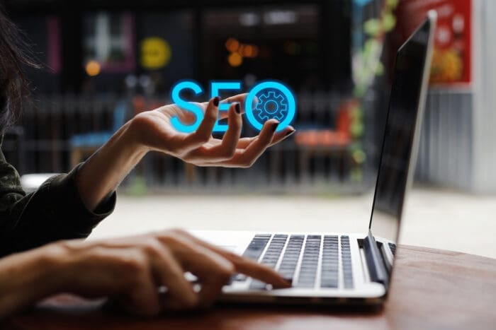 Person demonstrating SEO concept with holographic icons reflecting the importance of SEO in e-commerce