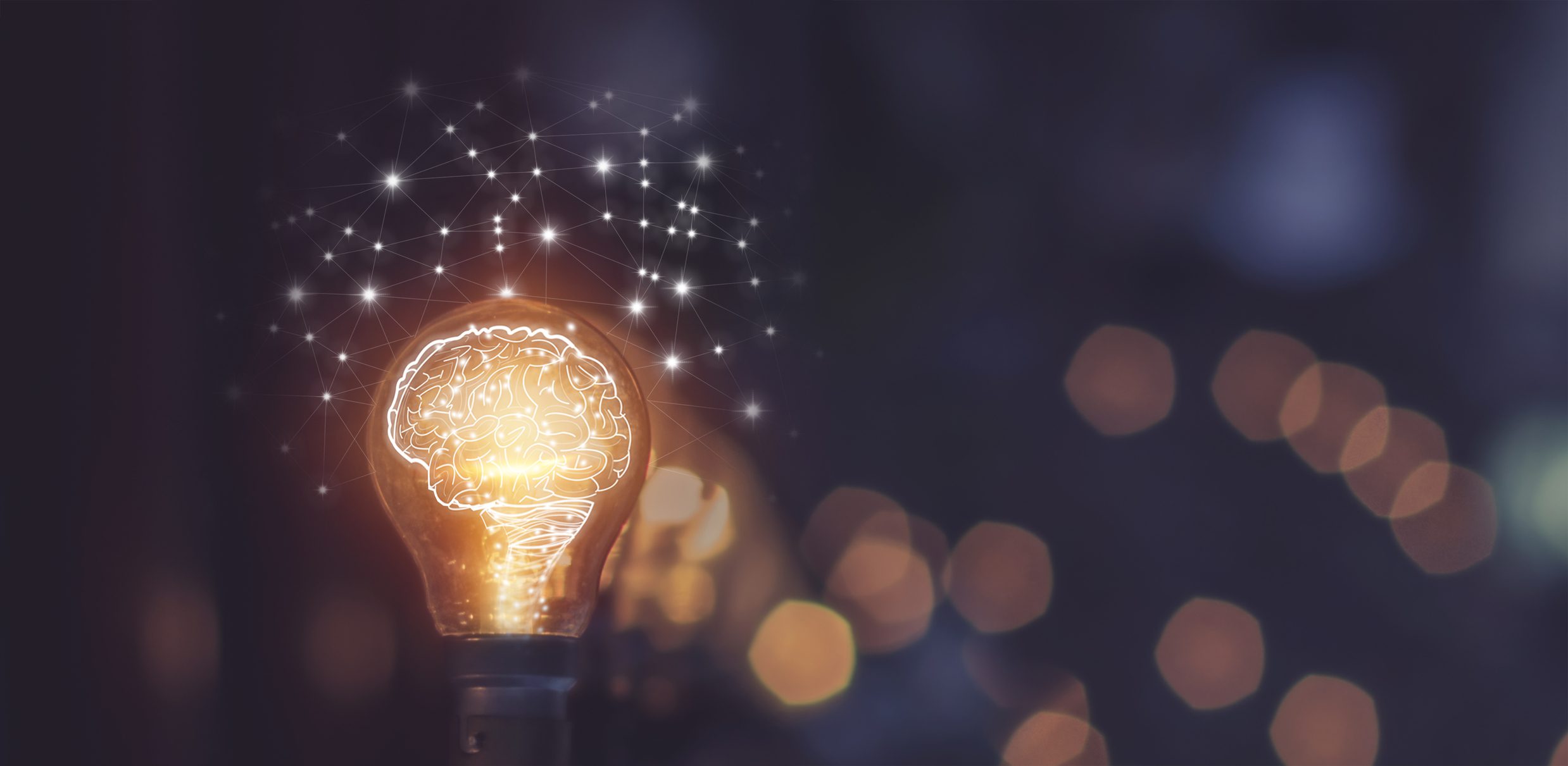 A glowing light bulb with an illustration of a brain inside it, symbolizing creativity and idea generation. Surrounding the bulb are interconnected lines and dots, reminiscent of strategic networks in wargame exercises. The background is dark and blurred, with various bokeh lights.