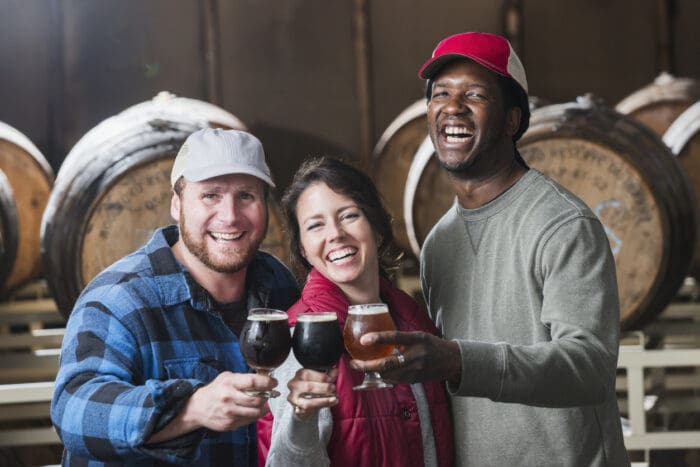 Friends toasting with beer in a brewery.