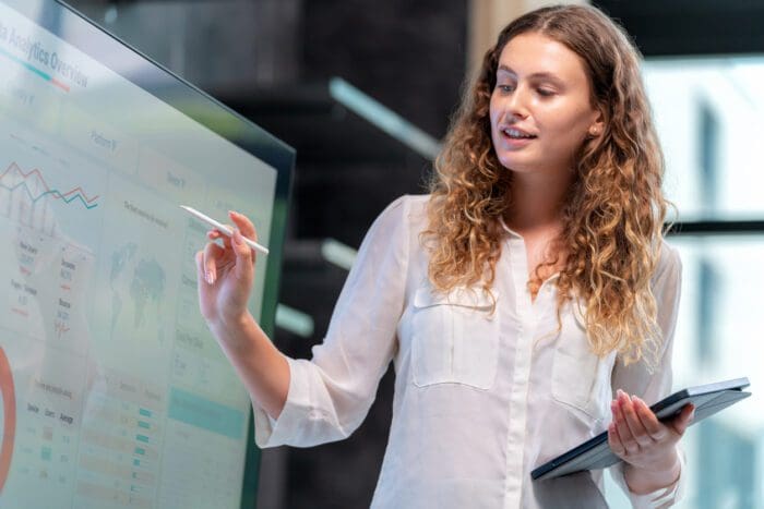 Woman presenting price elasticity data analytics on digital screen