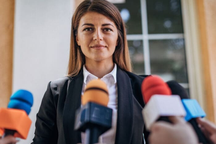 Woman addressing microphones at press conference