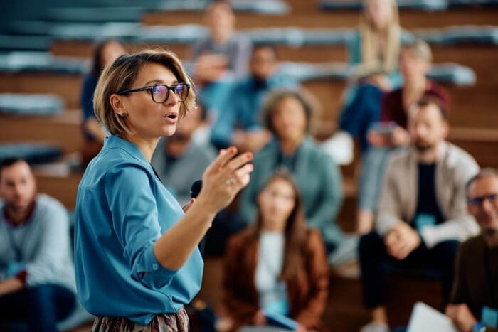 Woman lecturing in auditorium with attentive audience