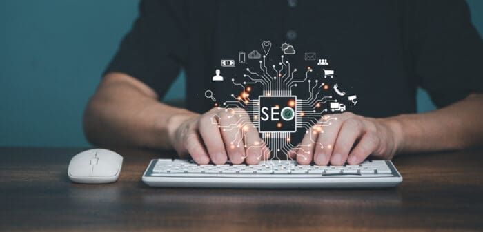 Person typing on keyboard with glowing SEO graphic