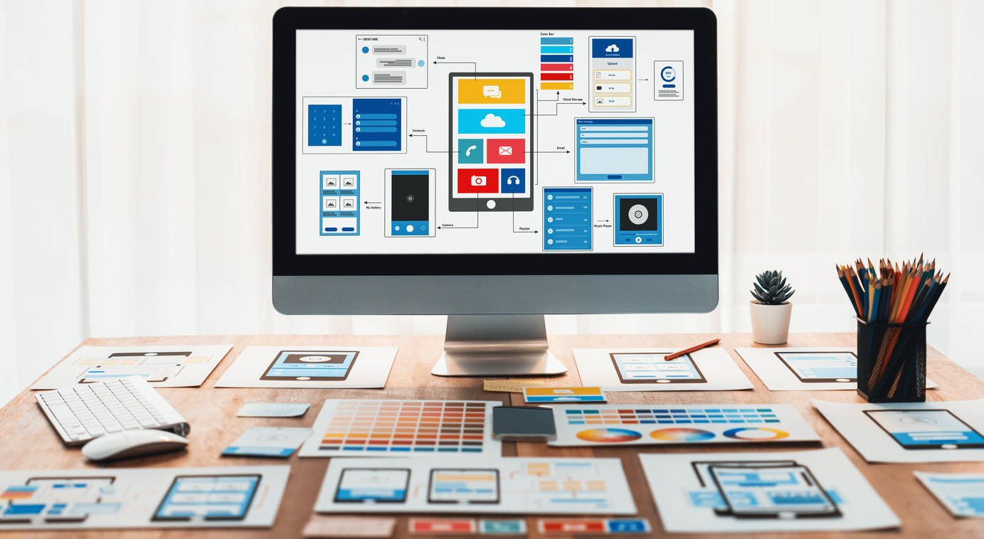 Desktop with UI/UX design layouts and digital devices