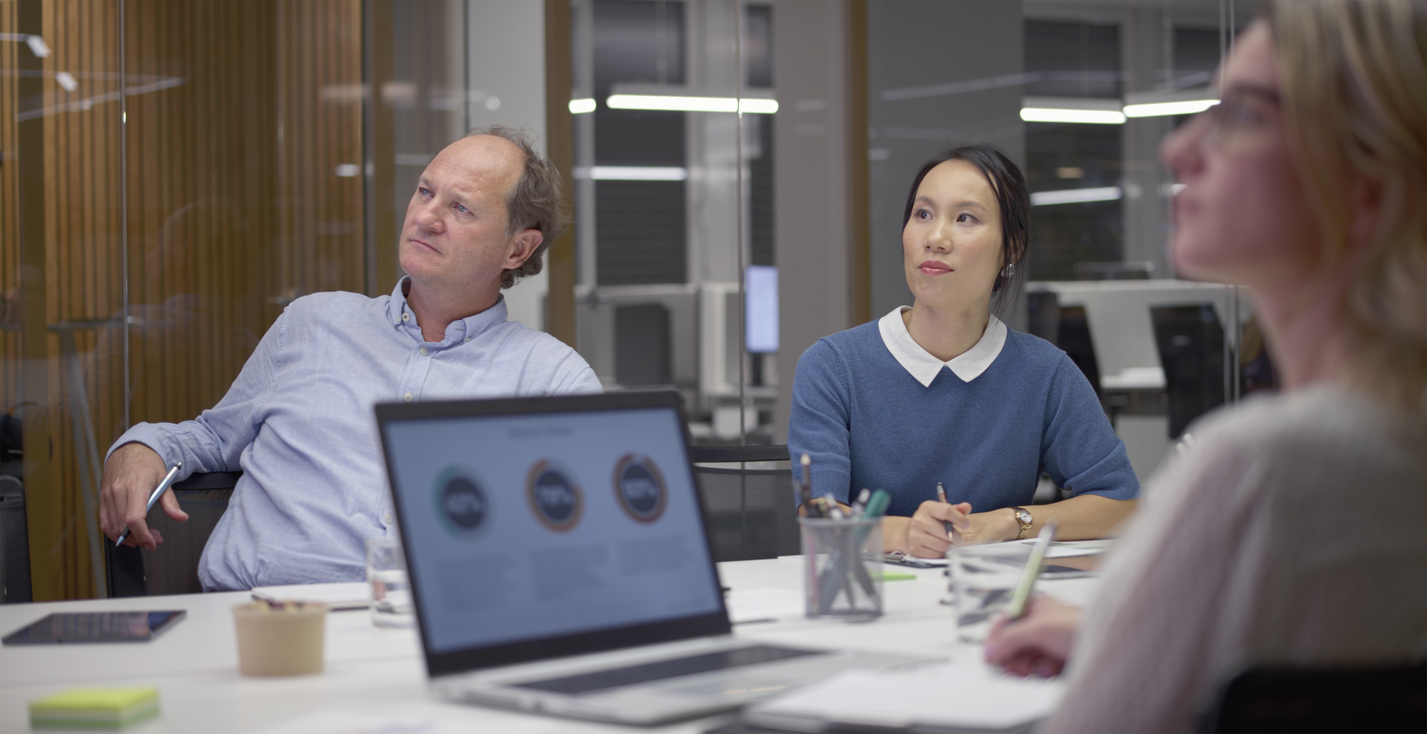 Marketing team analyzing data for customer acquisition strategy development with charts and graphs in a modern office setting.