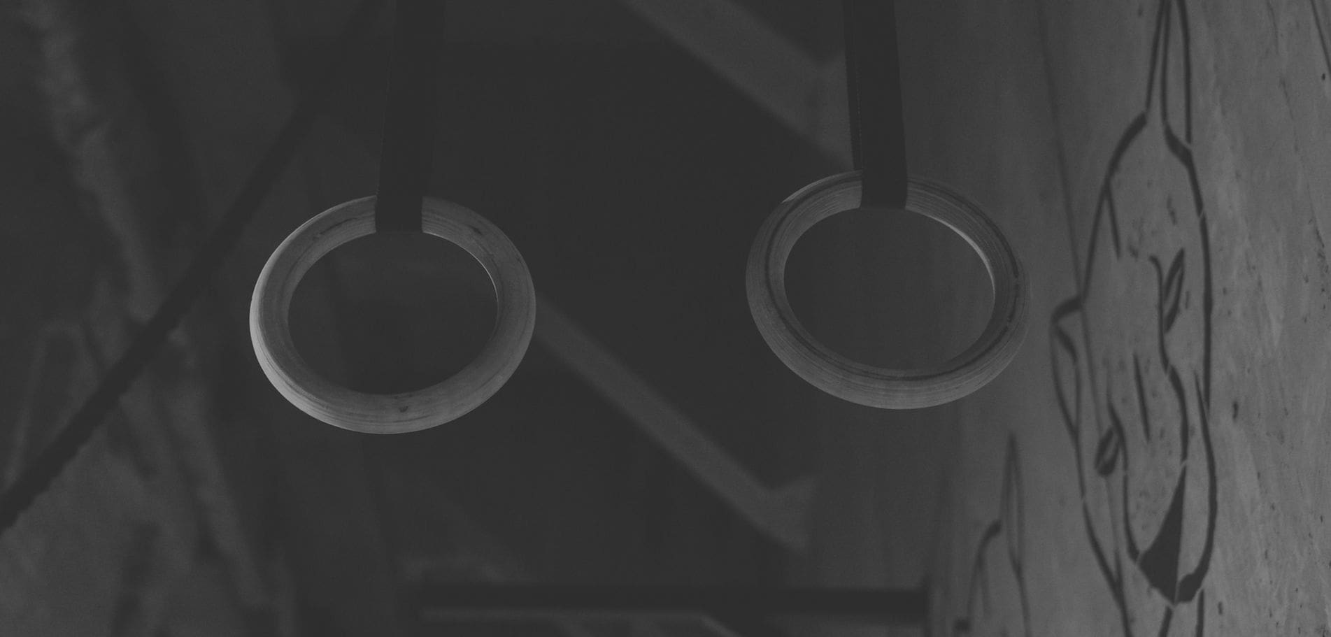 Monochrome gym rings hanging in industrial setting