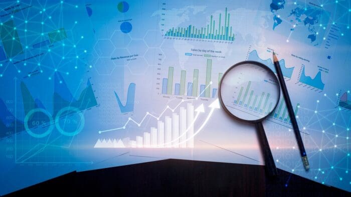 Data analysis charts with magnifying glass on desk