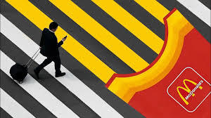 Person walking on striped crosswalk near McDonald's logo