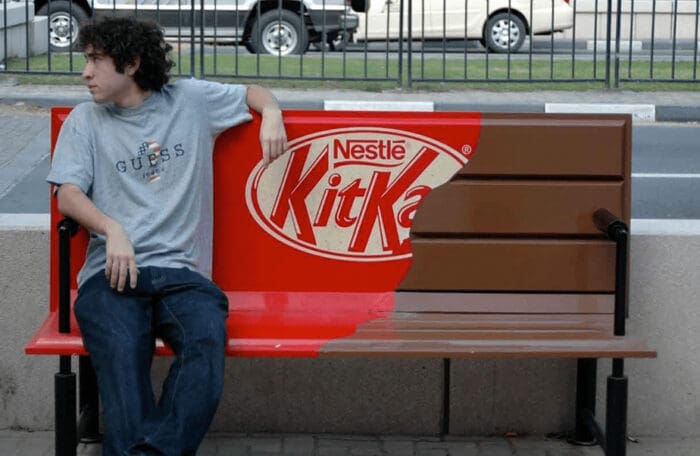 Man sitting on a KitKat-branded red bench