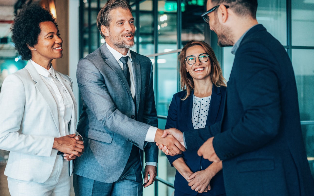 Business professionals greeting with a handshake in office