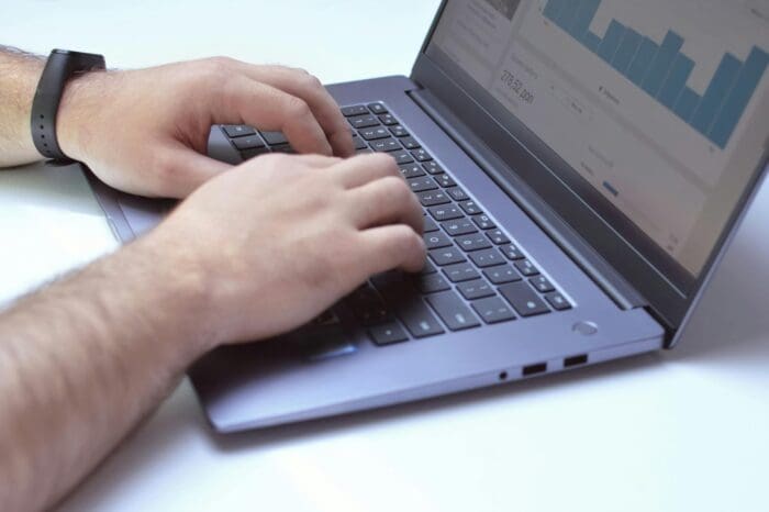 Person analyzing data graphs on laptop screen