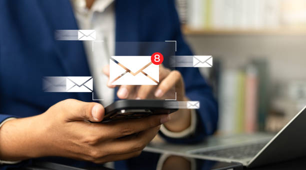 Person checks phone with new email notifications.