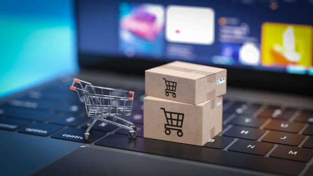 Mini shopping cart and cardboard boxes on laptop keyboard